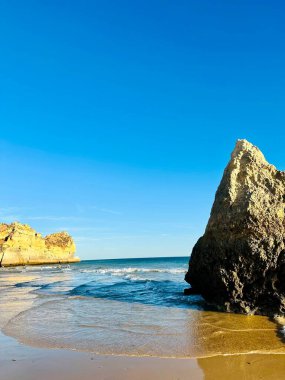 Praia Dos Tres Irmaos Sahili - Algarve Bölgesi, Portekiz, Avrupa. Yaz tatili konsepti. Güzel gün batımı. Dikey fotoğraf. Boşluğu kopyala