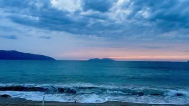 Gün batımında kumlu sahilde dalgaların gökyüzüne doğru aktığı manzara. Yüksek kaliteli FullHD görüntüler. 4K video. Zaman aşımı 