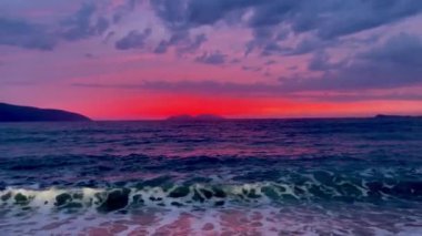 Gün batımında kumlu sahilde dalgaların gökyüzüne doğru aktığı manzara. Yüksek kaliteli FullHD görüntüler. 4K video