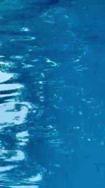 Mavi havuz suyu. Suyun soyut arkaplanı. Yaz tatili konsepti. Dikey video. Yüksek kaliteli FullHD görüntüler. 