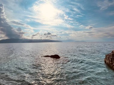  Rocky beach and crystal turquoise water of Ionian Sea in Albania. Copy space. Transparent water and waves. Summer holidays concept. clipart