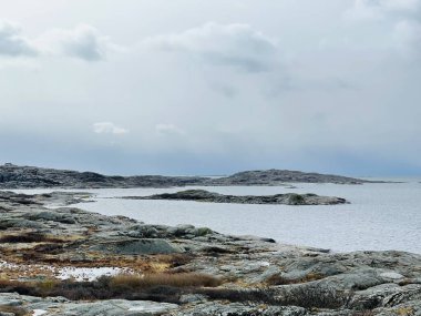 Vrango, Güney Göteborg Takımadası, İsveç - 8 Nisan 2022: Vrango, Güney Göteborg Takımadası, Bulutlu Gökyüzü 'nde beyaz ahşap evleri olan bir köy manzarası. 
