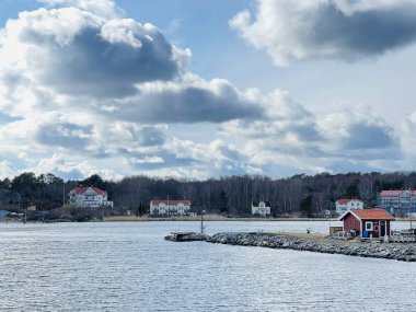 Donso, Güney Göteborg Takımadası, İsveç - 8 Nisan 2022: Donso, Güney Göteborg Takımadası 'nda ahşap evleri olan bir köy manzarası, Bulutlu gökyüzü. 
