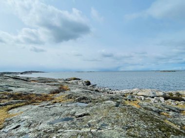 Vrango, Güney Göteborg Takımadası, İsveç - 8 Nisan 2022: Vrango, Güney Göteborg Takımadası, Bulutlu Gökyüzü 'nde beyaz ahşap evleri olan bir köy manzarası. 