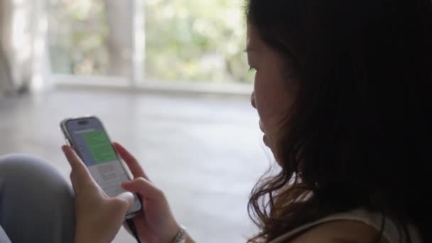 Жінка Азіатка Спілкується Другом Користуючись Смартфоном Удома — стокове відео