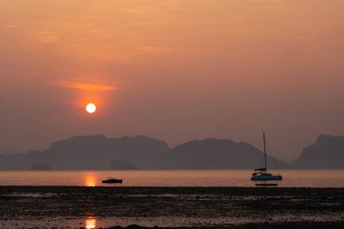 Sahil, Deniz ve Altın Gök manzarası Gün doğumunda yelkenliyle