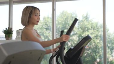 Genç Asyalı Kadın Spor Salonunda Eliptik Makineyle Antrenman