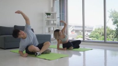 Evde birlikte yoga yapan genç Asyalı çift.