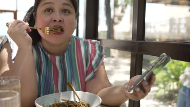 Asiatische Size Frau Isst Pasta Und Benutzt Handy Restaurant — Stockvideo