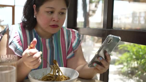 Asiatische Size Frau Isst Pasta Und Benutzt Handy Restaurant — Stockvideo