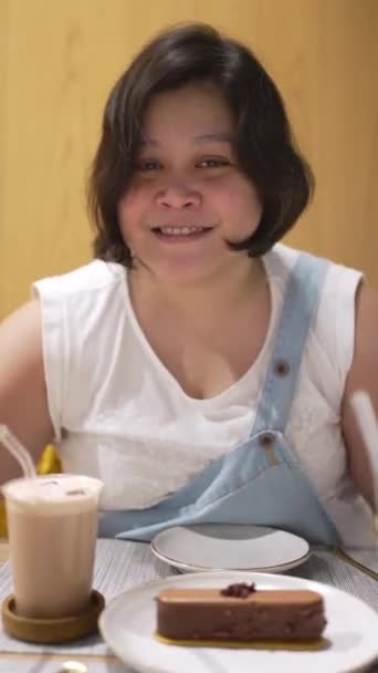 レストランでコーヒーとケーキを飲むアジアの太りすぎの女性の肖像画 — ストック動画