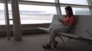 Terminal Havaalanında Biniş Beklerken Cep Telefonundan Sosyal Medya Okuyan Asyalı Kadın