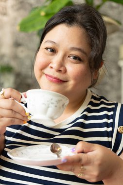 Güzel Plas 'ın portresi Gülümseyen Yüzlü Asyalı Kadın Restoranda Sıcak Çay İçiyor