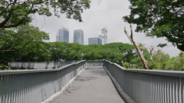 Bangkok, Tayland 'daki Benjakitti Parkı' nda Kıdemli Asyalı Kadın Köprüde Yürüyor