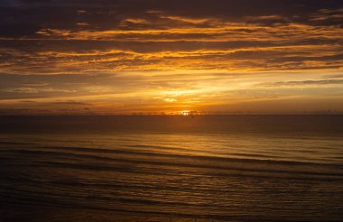 Altın Gökyüzü ile Sahilde ve Denizde Güzel Gün Doğumu