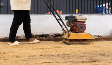 Paver için Kum Kompakt Plaka Kullanıcı İşçi. İnşaat Konsepti