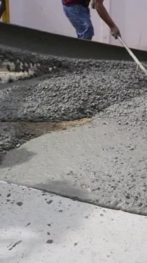 Yerdeki Betonu Yerleştirmek için İşçiler Kürek ve Tırmık Kullanıyor. İnşaat Konsepti ve Dikey Görüntü