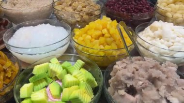 İçindekiler arasında Kırmızı Fasulye, Taro, Kavun, Pandan Pirinç Eriştesi ve Tatlı Tayland Tatlısı yapmak için Jöle veya Hindistan cevizi sütü