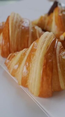 Sade, jambonlu ve peynirli çeşitli kruvasanların dönüşümlü ve dikey görüntüsü