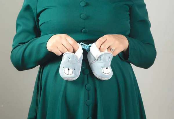 Young Pregnant Woman Hand Baby Shoes Stock Photo