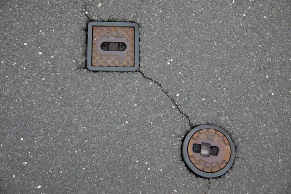 stock image Manhole cover and hydrant embedded in the road surface