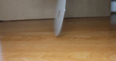 Bir DVD masanın üzerinde döner ve sendeleyerek masaya düşer.