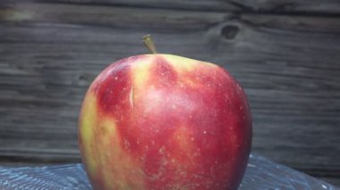 Tabakta kırmızı yanaklı elmalar hareket ediyor.