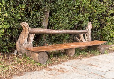 Parkta el yapımı ahşap tezgah duruyor, yeşil çalılarla çevrili..