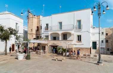 Polignano a Mare, Puglia, İtalya - 4 Ekim 2023: Bari ilinin Polignano a Mare köyünde bar ve restoranların bulunduğu meydan.