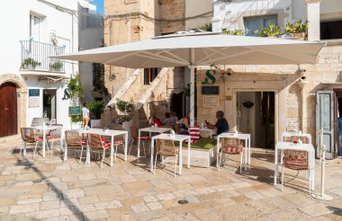 Polignano a Mare, Puglia, İtalya - 4 Ekim 2023: Bari ilinin Polignano a Mare köyünde bar ve restoranların bulunduğu meydan.