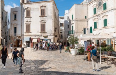 Polignano a Mare, Puglia, İtalya - 4 Ekim 2023: Bari ilinin Polignano a Mare köyünde bar ve restoranların bulunduğu meydan.
