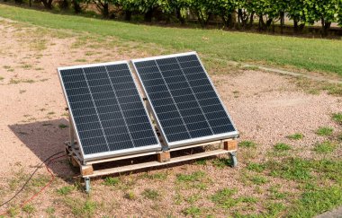 Ev bahçesindeki ahşap palette fotovoltaik paneller. Yeşil enerji kavramı.