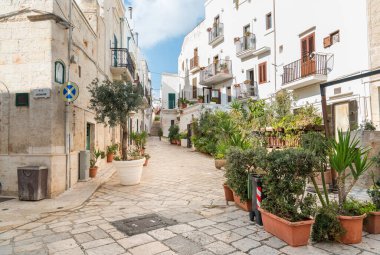 Bari, Puglia, İtalya 'da Polignano a Mare köyünün merkezinde bar ve restoranları olan dar bir sokak.
