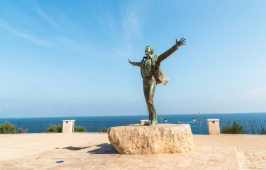 İtalyan müzisyen ve politikacı Domenico Modugno 'nun bronz heykeli, Polignano a Mare' de deniz kenarında, Bari, Puglia, İtalya