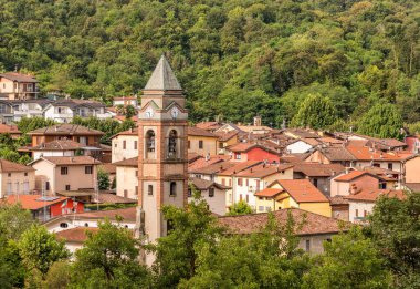 Varese 'deki Lavena Ponte Tresa, Varese' deki Aziz Peter ve Paul antik kilisesinin çan kulesi Varese, Lombardy, İtalya 'daki Lugano Gölü' ne bakıyor.
