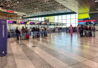 Ferno, Milan-Malpensa, Italy - September 29, 2024: Passengers lined up for check-in inside the Milan-Malpensa Airport Terminal 1. clipart