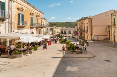Ragusa, Sicilya, İtalya - 7 Ekim 2024: Ragusa İbla 'nın tarihi merkezinde açık hava barları ve restoranları olan Piazza Duomo manzarası.
