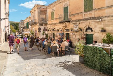 Ragusa, Sicilya, İtalya - 7 Ekim 2024: Halk Ragusa İbla 'nın tarihi merkezinde bir açık hava restoranında öğle yemeği yiyor.