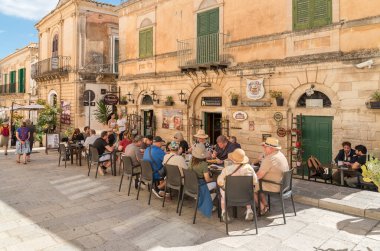 Ragusa, Sicilya, İtalya - 7 Ekim 2024: Halk Ragusa İbla 'nın tarihi merkezinde bir açık hava restoranında öğle yemeği yiyor.