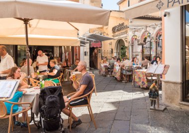 Taormina, Sicilya, İtalya - 29 Eylül 2024: İnsanlar Messina eyaletinin tarihi merkezi Taormina 'daki açık hava barında içki içiyorlar.