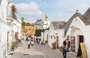 Alberobello, Puglia, İtalya - 5 Ekim 2023: Bari ilinin antik Alberobello köyünü ziyaret eden turistler.