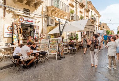 Noto, Sicilya, İtalya - 3 Ekim 2024: Noto 'nun tarihi merkezini gezen turistler, açık hava barları, restoranlar ve hediyelik eşya dükkanları.