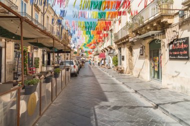 Noto, Sicilya, İtalya - 3 Ekim 2024: Noto 'nun tarihi merkezinde açık bar, restoran ve hediyelik eşya dükkanları olan bir sokak.