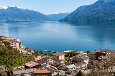 İsviçre 'nin Ticino kantonundaki İsviçre Alpleri tarafından çevrelenmiş Brissago köyünden Maggiore Gölü manzarası.