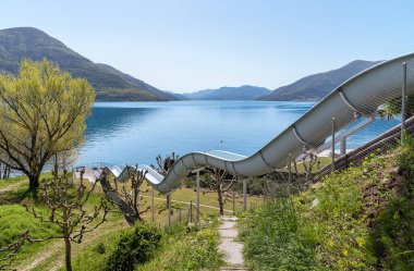 İsviçre, Canton Ticino 'daki Maggiore Gölü' ndeki Brissago sahilindeki su kaydırağı..