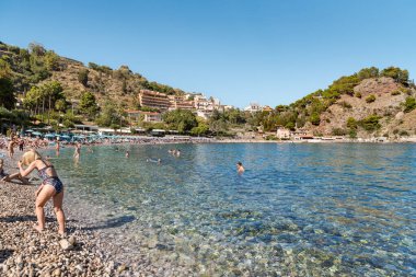 Taormina, Sicilya, İtalya - 29 Eylül 2024: İnsanlar Taormina 'daki Isola Bella Plajı' nda yüzüyor ve berrak suların tadını çıkarıyorlar.
