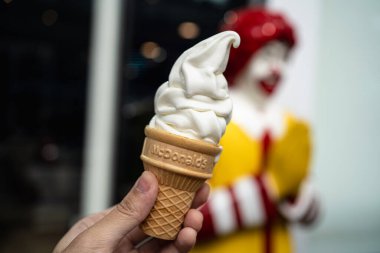 Bangkok, Tayland - 24 Mayıs 2024: Restoranın önünde McDonald 's vanilya konisi tutan bir adam.