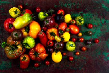 Eski yeşil ve kırmızı bir tahta üzerinde eski domatesler.