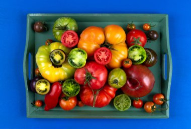 Yaşlı domatesler yeşil bir tepside ikiye bölünmüş..