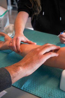 Öğrenciler atardamar koluyla idman yapıyor. Kan örneği için arter ve venöz delikler açılıyor. Kol, sefalik, bazilik, radyal ve kübital damarların yanı sıra infüzyon ve kan örnekleme için radyal ve brakiyal arterler üzerinde çalışmalara izin verir..